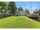 Expansive backyard features a well-kept lawn, mature trees, and a wooden fence at 6102 Primrose Ave, Indianapolis, IN 46220