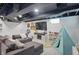 Cozy finished basement features a comfortable sectional sofa, a play area, and modern recessed lighting at 6102 Primrose Ave, Indianapolis, IN 46220