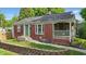 Charming brick home with a green door, cozy front porch, and well-manicured front yard at 6102 Primrose Ave, Indianapolis, IN 46220