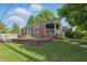 A charming brick home with a cozy front porch, a retaining wall, and a well-manicured lawn at 6102 Primrose Ave, Indianapolis, IN 46220