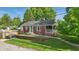 Charming brick home with well-kept lawn, quaint porch, and ample greenery at 6102 Primrose Ave, Indianapolis, IN 46220