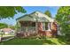 Charming brick home featuring a cozy front porch with hanging floral baskets and well-maintained landscaping at 6102 Primrose Ave, Indianapolis, IN 46220