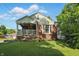 Charming brick home featuring a cozy front porch with hanging floral baskets and a well-manicured lawn at 6102 Primrose Ave, Indianapolis, IN 46220