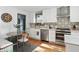 Bright kitchen featuring modern appliances, stylish backsplash, and a cozy dining nook with bench seating at 6102 Primrose Ave, Indianapolis, IN 46220