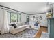 Bright living room with a large window, comfortable seating, and a stylish area rug at 6102 Primrose Ave, Indianapolis, IN 46220