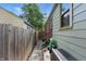 Side yard view, showing walkway with pea stone, partial brick wall, and fence at 6102 Primrose Ave, Indianapolis, IN 46220