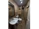 Bathroom with a pedestal sink, toilet, and a tiled shower with a glass door at 6126 Regina Cir, Indianapolis, IN 46224