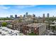 An aerial view captures the downtown skyline behind residential buildings with rooftop details at 630 N College Ave # 105, Indianapolis, IN 46204