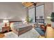 Cozy bedroom with large windows, natural light, brick accent wall, and comfortable furnishings at 630 N College Ave # 105, Indianapolis, IN 46204