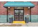 Inviting entrance with a green awning, planters, and double doors showcases the building's address at 630 N College Ave # 105, Indianapolis, IN 46204