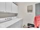 Bright laundry area includes a white washer and dryer, complemented by upper cabinets for ample storage at 630 N College Ave # 105, Indianapolis, IN 46204