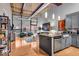 Open-concept living area featuring hardwood floors, exposed ceilings, and a modern kitchen at 630 N College Ave # 105, Indianapolis, IN 46204