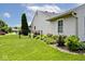 Landscaped backyard with lush flower beds, green grass, and a secure black fence at 6406 Longhorn Ct, Indianapolis, IN 46237
