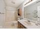 Bathroom with a shower-tub combo, single sink vanity, and honeycomb-shaped shelves at 6406 Longhorn Ct, Indianapolis, IN 46237
