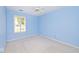 A brightly painted blue bedroom with neutral carpet, a white ceiling fan, and a window with white shutters at 6406 Longhorn Ct, Indianapolis, IN 46237