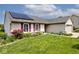 Home with solar panels, large front yard, and colorful flowerbeds around the perimeter at 6406 Longhorn Ct, Indianapolis, IN 46237