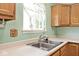 Bright kitchen featuring a stainless steel sink and cream colored countertop at 6406 Longhorn Ct, Indianapolis, IN 46237