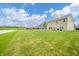 Backyard featuring a green lawn, a pond, and a home with light green siding at 6579 Aster Dr, Pendleton, IN 46064