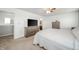 Bedroom featuring tan carpet, ceiling fan, and a large TV sitting atop a wooden dresser at 6579 Aster Dr, Pendleton, IN 46064