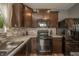 Well-equipped kitchen featuring black appliances, dark cabinetry, and a stone backsplash at 6579 Aster Dr, Pendleton, IN 46064