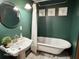 Charming bathroom with a clawfoot tub, pedestal sink, and elegant wall art at 675 W Morgan St, Martinsville, IN 46151