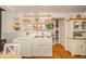 A bright kitchen showcases open shelving with decor, light cabinets and hardwood floors at 6762 S State Road 67, Pendleton, IN 46064