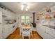 Bright eat-in kitchen with white cabinetry, an eating space, and a wood-burning stove, perfect for Gathering meals at 6762 S State Road 67, Pendleton, IN 46064