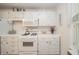A kitchen showcases white cabinets, a gas range, and vintage distressed detailing at 6762 S State Road 67, Pendleton, IN 46064