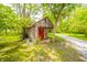 Rustic outbuilding with a red door and a quaint, natural setting at 6762 S State Road 67, Pendleton, IN 46064