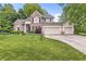 Charming two-story home with brick and siding exterior, manicured lawn, and attached three-car garage at 6833 Bluffridge Ln, Indianapolis, IN 46278