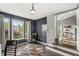 Home office featuring dark blue walls, hardwood floors, and three large windows offering natural light and outdoor views at 6833 Bluffridge Ln, Indianapolis, IN 46278