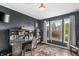Home office with a built-in desk, dark blue walls, and three large windows with a view of the outdoors at 6833 Bluffridge Ln, Indianapolis, IN 46278