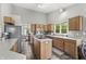 Bright kitchen with light wood cabinets, an island with cooktop, stainless steel appliances, and lots of windows at 6833 Bluffridge Ln, Indianapolis, IN 46278