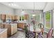 Bright eat-in kitchen boasts warm wood cabinetry, an island cooktop, pendant lighting, and views to the backyard at 6833 Bluffridge Ln, Indianapolis, IN 46278
