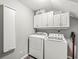 Well-equipped laundry room featuring a washer, dryer, and built-in storage cabinets at 6833 Bluffridge Ln, Indianapolis, IN 46278