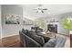 Comfortable living room with gray couches, fireplace, ceiling fan, wood floors, and large windows with natural light at 6833 Bluffridge Ln, Indianapolis, IN 46278