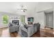 Bright living room features a fireplace, ceiling fan, hardwood floors, and large windows offering great natural light at 6833 Bluffridge Ln, Indianapolis, IN 46278