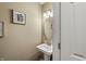 Neutral powder room features a pedestal sink, an oval mirror, and updated light fixture at 6833 Bluffridge Ln, Indianapolis, IN 46278