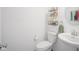 Well-lit half bathroom featuring a modern pedestal sink, floating shelves, and sleek fixtures for added convenience at 6871 Adalene Ln, Carmel, IN 46033