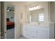 Bright bathroom featuring double sinks, white cabinets, granite countertops, and a view into the bedroom at 6871 Adalene Ln, Carmel, IN 46033