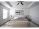Bright bedroom featuring neutral walls, tray ceiling with ceiling fan, and a comfortable bed at 6871 Adalene Ln, Carmel, IN 46033
