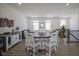 Spacious dining area with a round table, white chairs, and a modern storage cabinet on sleek wood floors at 6871 Adalene Ln, Carmel, IN 46033