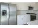 Close-up on stainless steel refrigerator, oven, microwave, white cabinets, subway tile backsplash, and quartz counters at 6871 Adalene Ln, Carmel, IN 46033
