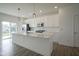 Bright kitchen boasts white cabinets, stainless steel appliances, quartz countertops, and a large island at 6871 Adalene Ln, Carmel, IN 46033