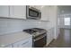 Close-up on stainless steel oven, range, white cabinets, subway tile backsplash, and quartz counters at 6871 Adalene Ln, Carmel, IN 46033