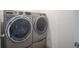 Close-up of a modern, front-loading washing machine and dryer in a laundry area at 6871 Adalene Ln, Carmel, IN 46033