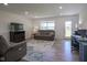 Inviting living room featuring a comfortable sofa, a television, and a door to the backyard at 6871 Adalene Ln, Carmel, IN 46033