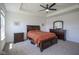Comfortable main bedroom featuring a large bed, tray ceiling, and matching dark wood furniture on plush carpeting at 6871 Adalene Ln, Carmel, IN 46033
