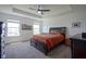 Spacious main bedroom with tray ceiling, ample natural light, and dark wood furniture for a relaxing retreat at 6871 Adalene Ln, Carmel, IN 46033