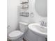 Clean, modern powder room with pedestal sink, round mirror, and floating shelves at 6871 Adalene Ln, Carmel, IN 46033